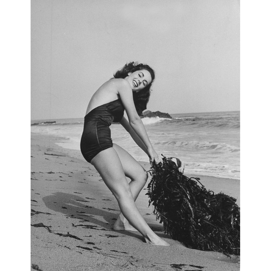 Elizabeth Taylor - On Beach Pulling Seaweed Photo Print (8 x 10) - Item DAP17742 Image 1