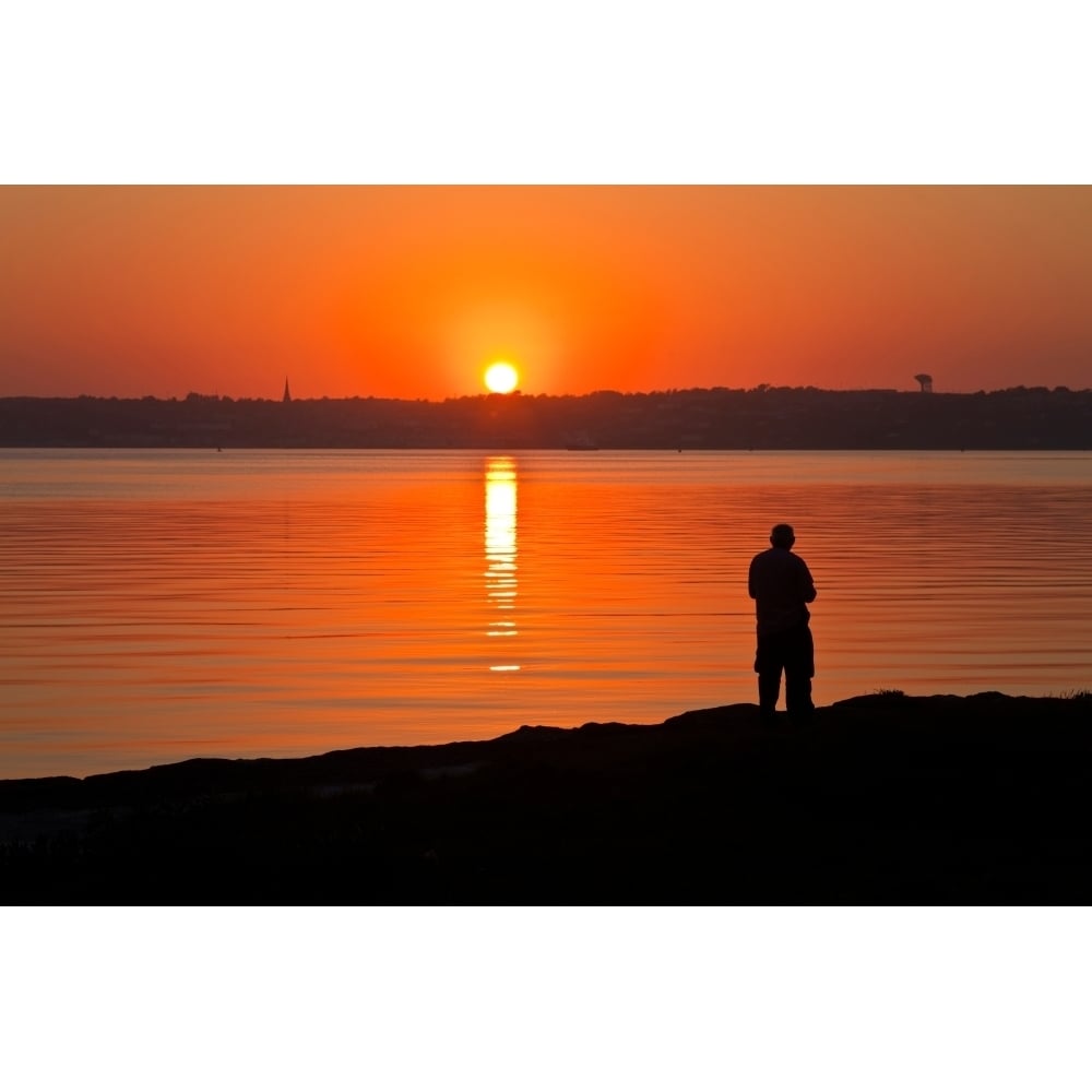 Sunset and lone figure Cork Harbour with Cobh on far side County Cork Ireland Poster Print (9 x 27) Image 1