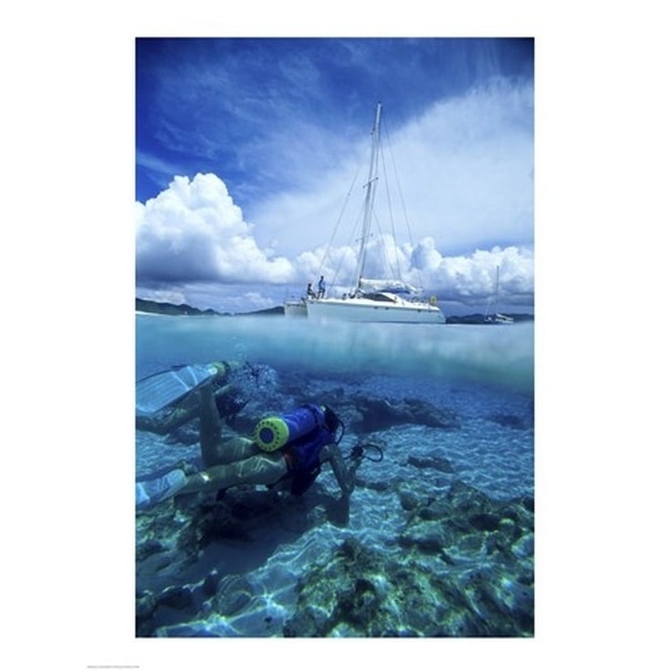 Scuba diver in the water with a sail boat in the background British Virgin Islands Poster Print (18 x 24) Image 1