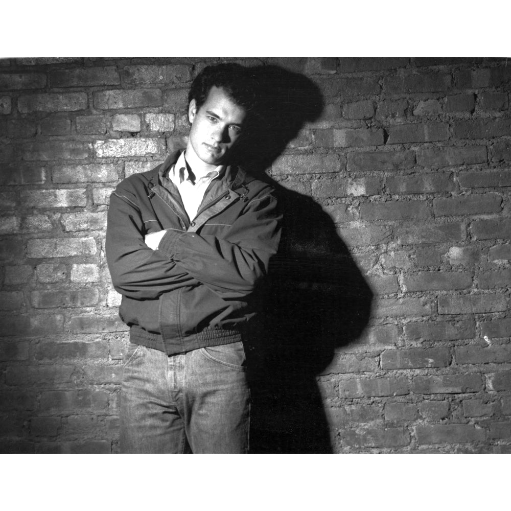 Tom Hanks with arms crossed in front of a brick wall Photo Print Image 1