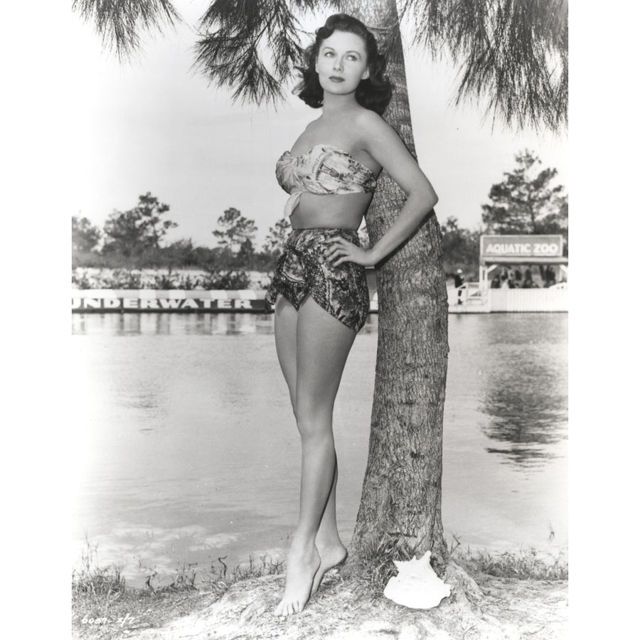 Rhonda Fleming leaning on a tree trunk in a bikini Photo Print Image 1