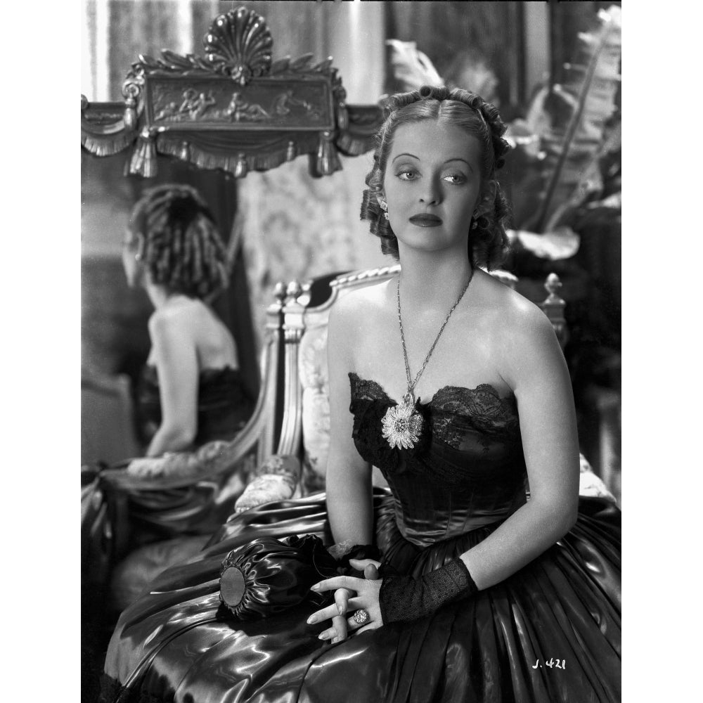 Bette Davis Posed with Hands on the Lap with Fingers Crossed in Black Strapless Gown and Black Gloves Photo Print Image 1