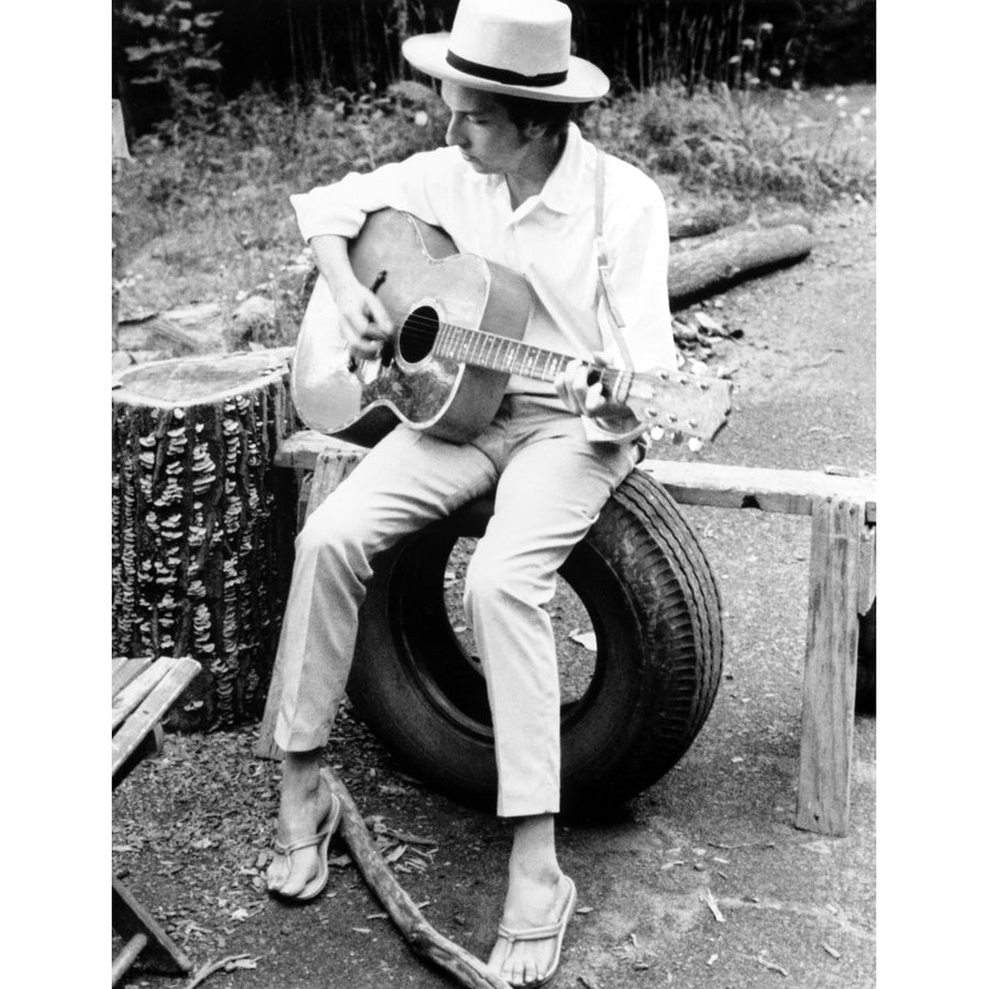 Bob Dylan Seated on Wheel Playing Guitar wearing White Long Sleeves and Slippers Photo Print Image 1