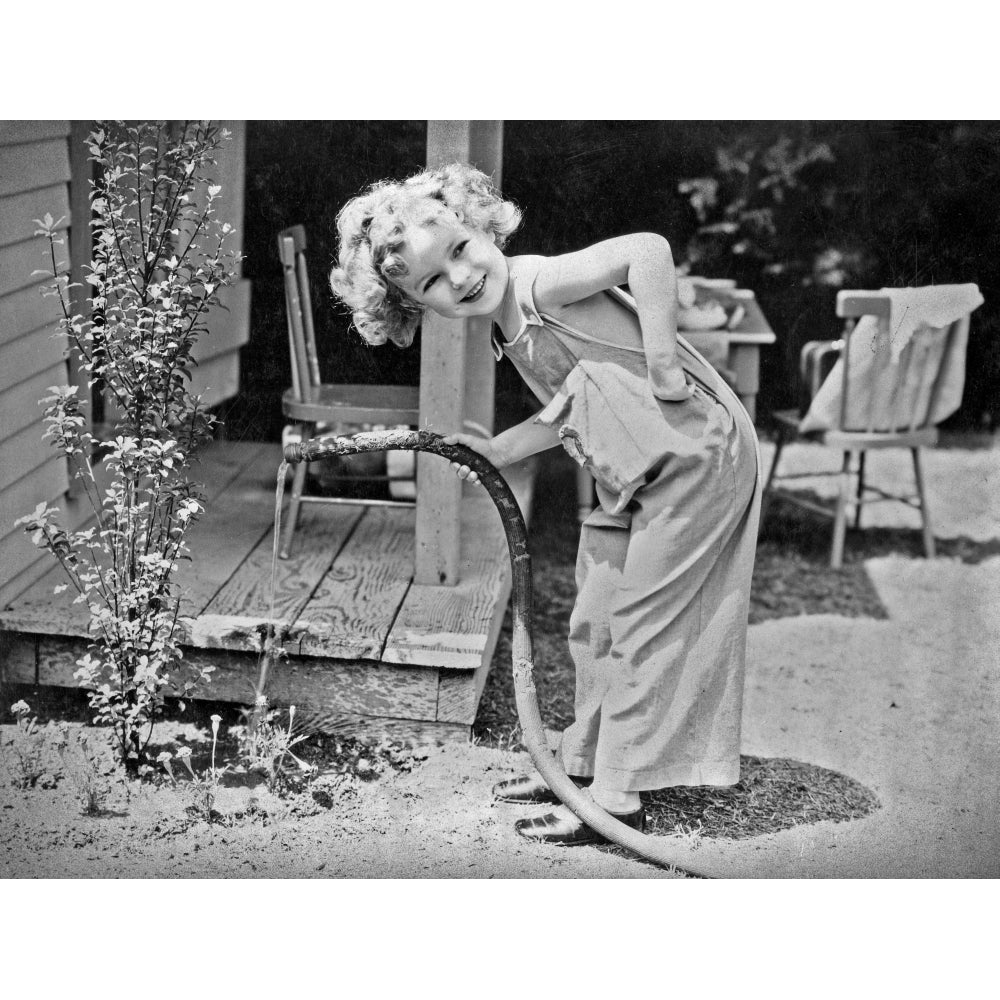 Shirley Temple Posed in Jumper suit watering flowers Photo Print Image 1