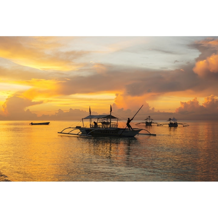 Beautiful sunrise in Alona Beach a man moving his boat to reach the shore with Image 2