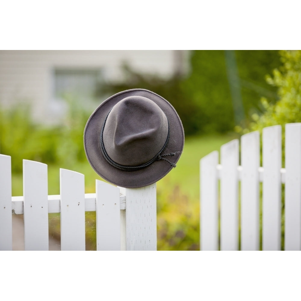 A hat hanging on the post of a white picket fence; Vancouver British Columbia Canada Poster Print Image 2