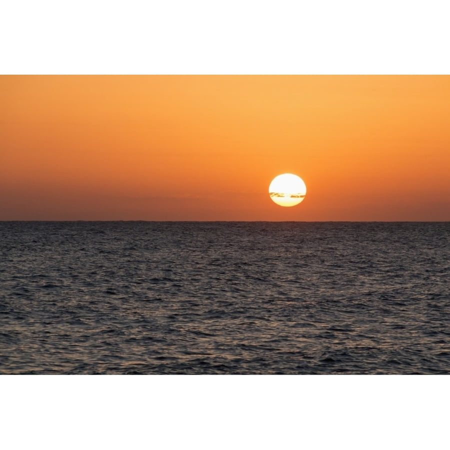 Glowing sun over the ocean and horizon at sunset; Paphos Cyprus Poster Print Image 1