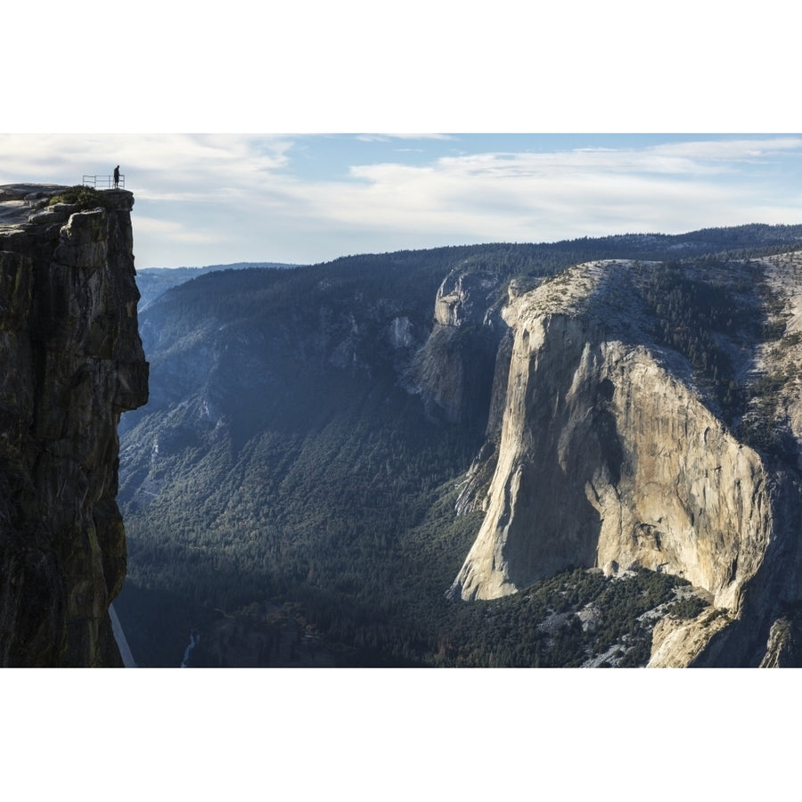 A Yosemite National Park visitor stands at Taft Point which overlooks Yosemite Valley and El Capitan; California Unite 1 Image 1