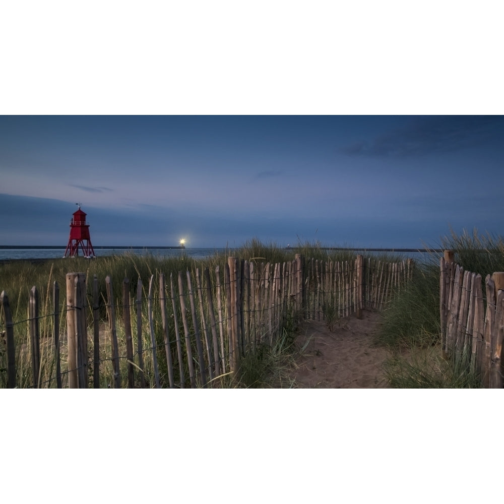 A sand pathway lined with a wooden fence leading to the beach with the Herd Groyne Lighthouse on the waters edge; South Image 1