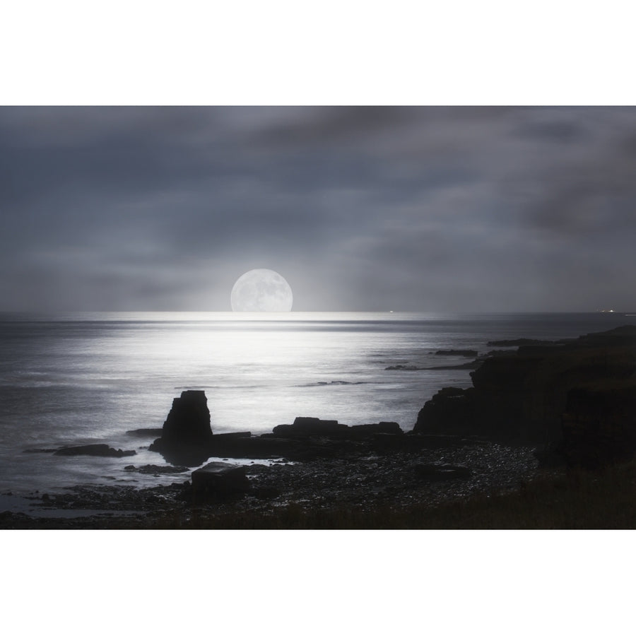 Sun rising over the horizon of the ocean with a silhouetted coastline; South Shields Tyne and Wear England Image 1