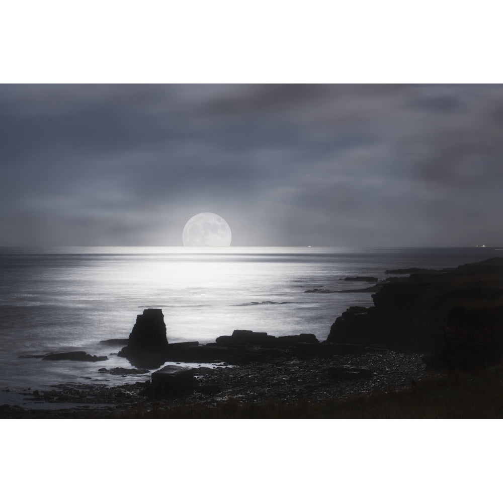 Sun rising over the horizon of the ocean with a silhouetted coastline; South Shields Tyne and Wear England Image 2