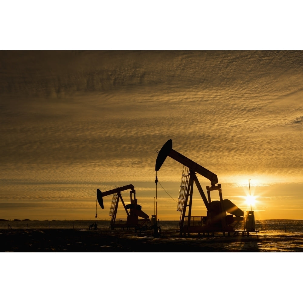 Silhouette of two pump jacks at sunrise with sun burst and colourful clouds in the sky; Alberta Canada Print Image 2