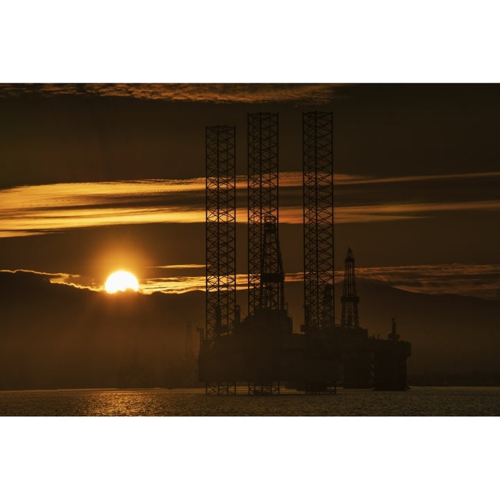 Oil drilling rigs out in the ocean with a view of the coastline and golden sunset; Cromarty Invergordon Scotland 19 x 12 Image 2