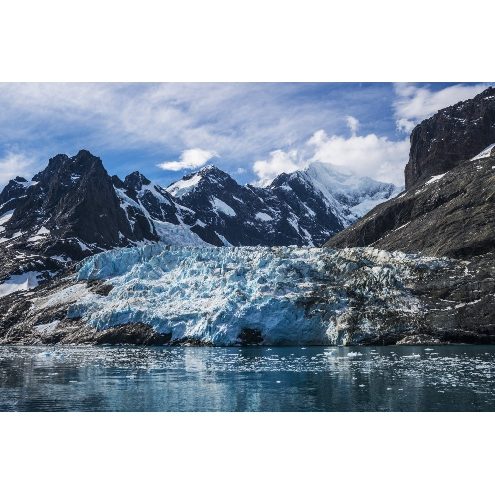 Blue glacier between snow-capped mountains and fjord; Antarctica Poster Print Image 1