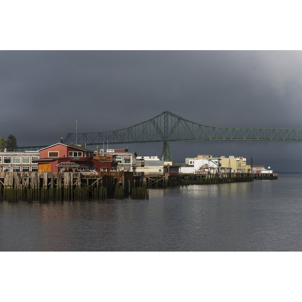 Sunlight warms the riverfront with storm clouds over the Astoria-Megler bridge; Astoria Oregon United States of Americ Image 2