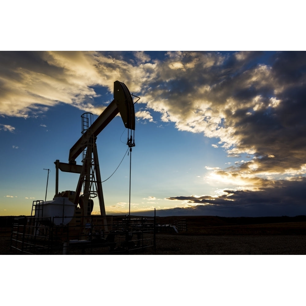 Silhouette of pump jack with dramatic storm clouds and blue sky; Alberta Canada Poster Print by Michael Interisano / De Image 1