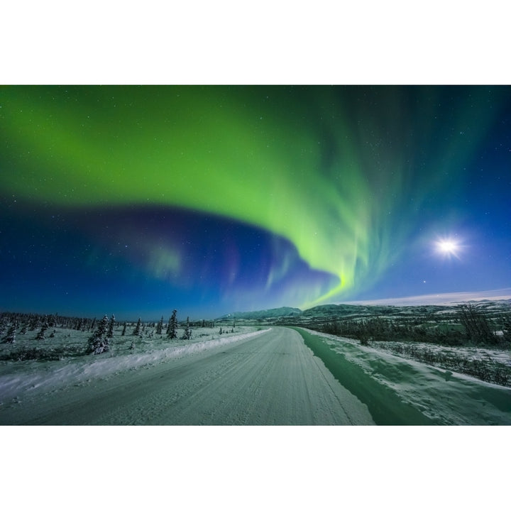 The moon and aurora shine in the night sky over a snow covered Richardson Highway south of Delta Junction; Alaska Unite Image 1