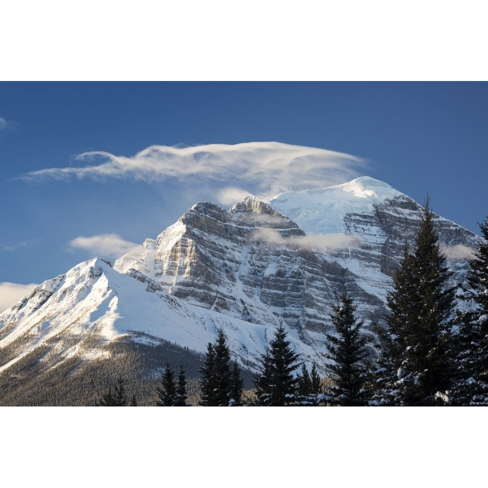 Snow-covered mountain with wispy cloud formation on peak and blue sky Banff National Park; Lake Louise Alberta Canada by Image 1