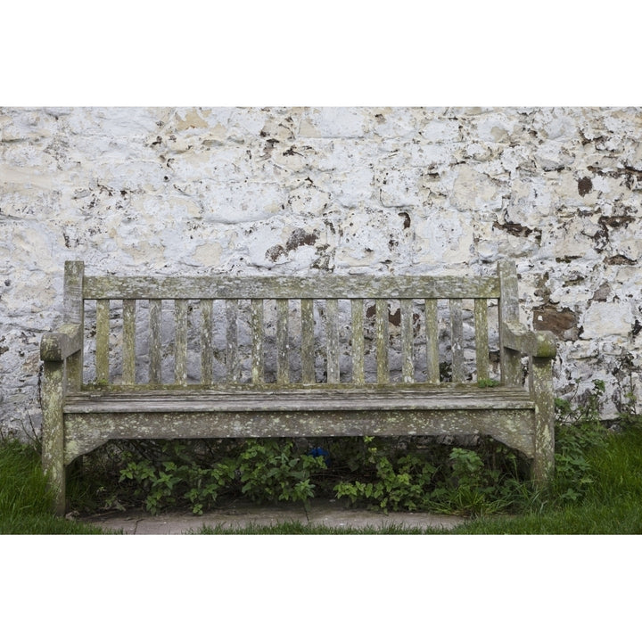 A Wooden Bench With Peeling Paint Against A White Wall; Northumberland England Poster Print Image 1