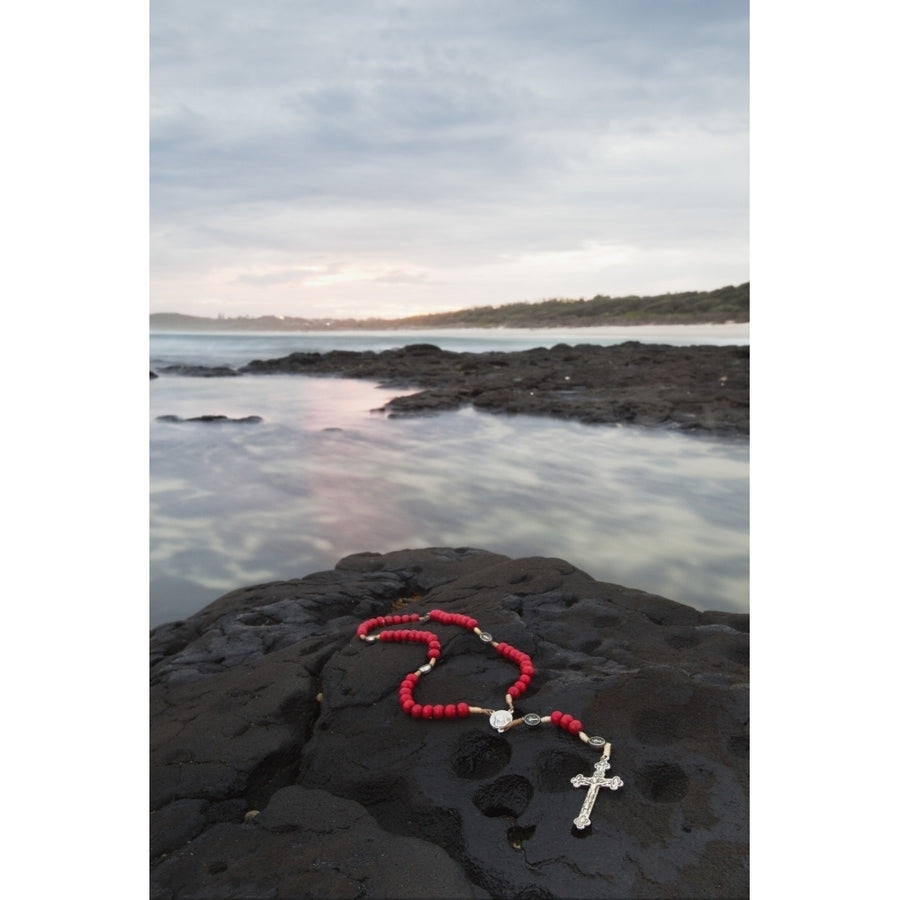 A Cross And Rosary Beads Laying On A Rock At Flat Rock; Ballina South Wales Australia Poster Print by Marcos Welsh Image 1