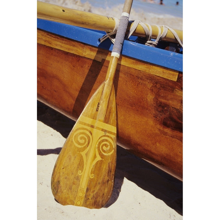 Wooden paddle and outrigger canoe on beach Poster Print Image 2