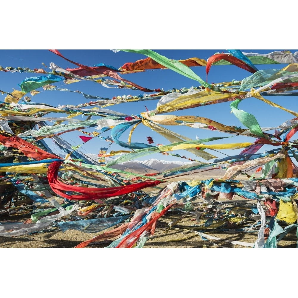 Colourful Tibetan prayer flags under the strong wind with white mountain tops in the background; Qinghai province Tibet Image 1