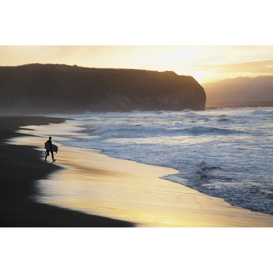 A surfer walks to the water at sunrise Santa Barbara Island; Sao Miguel Island Acores Portugal Poster Print Image 1