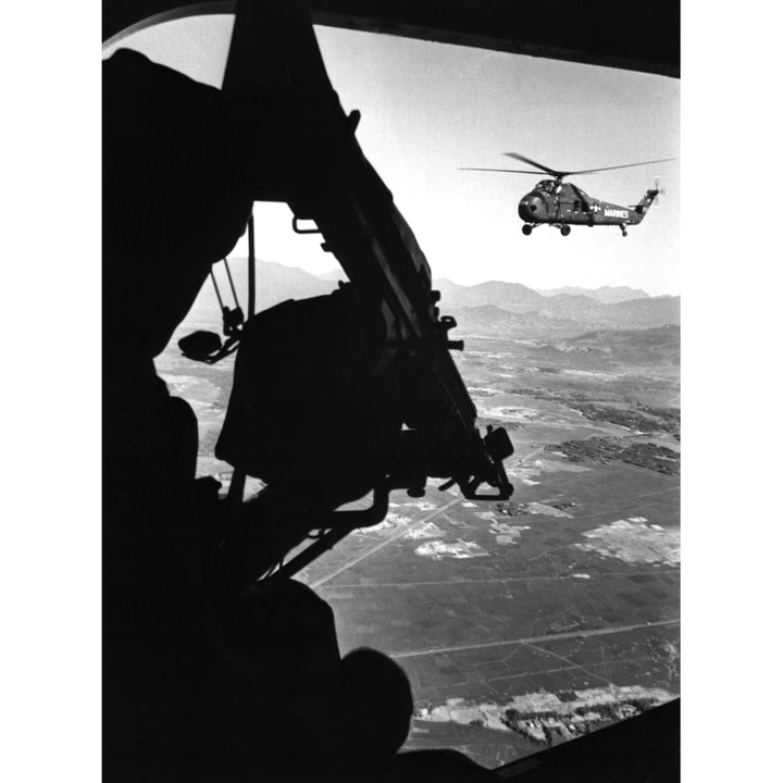 Vietnam War. Us Army Helicopter In Flight Viewed From Behind The Door Gunner Of A Companion Helicopter. Ca. 1965. Image 1