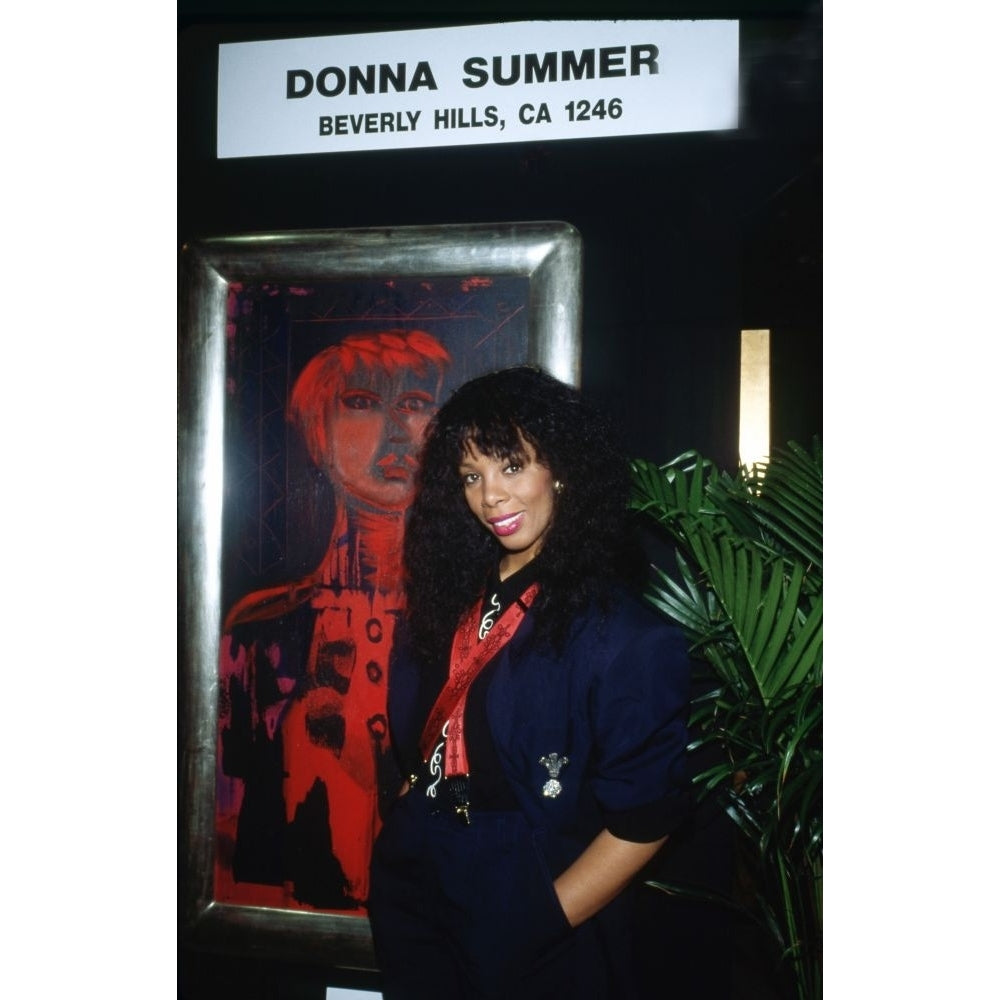 Singer and artist Donna Summer at a gallery showing of her art posing in front of one of her paintings. 1980s. Photo: Image 1