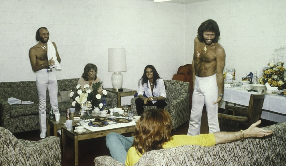 the Bee Gees with two women in a living room Photo Print Image 1