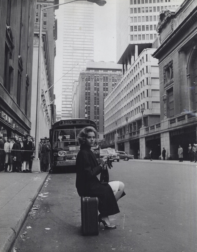 Jane Fonda sitting on a suitcase on a city street Photo Print Image 1