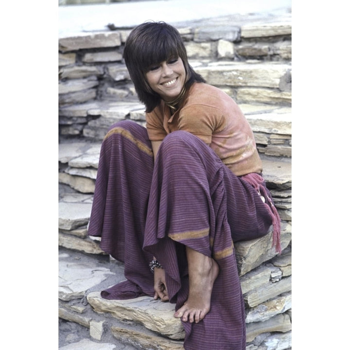 Jane Fonda sitting on a stone wall Photo Print Image 1