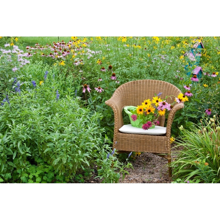 Wicker chair with basket and birdhouse in flower garden Marion County Illinois USA Poster Print Image 1