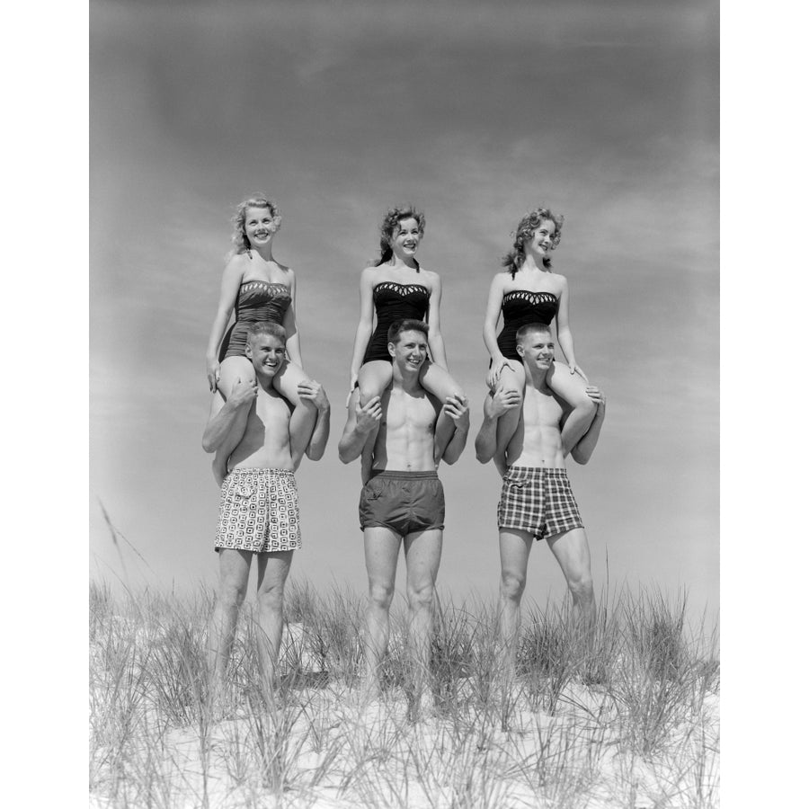 1950s-1960s Three Couples At Beach On Dunes With Women In Identical Bathing Suits Sitting On MenS Shoulders Print By Image 1