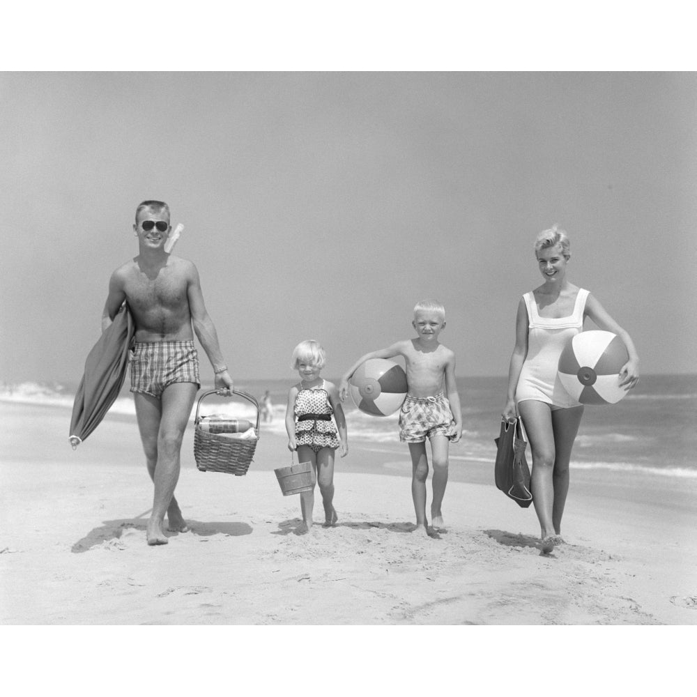 1950s Family Of Four Walking Towards Camera With Beach Balls Umbrella Picnic Basket And Sand Bucket Print By Vintage Image 1