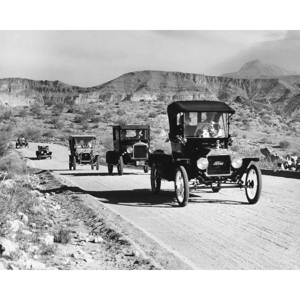 1960s Line Of 1920s Model T And 1930s Model A Ford Automobiles On Gravel Road In Southwest Usa Print By Vintage Image 1