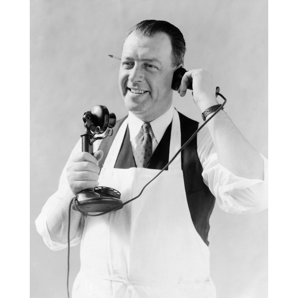 1920s Man In Apron Butcher Cook Talking On Candlestick Telephone Pencil In Ear Print By Vintage Collection Image 1