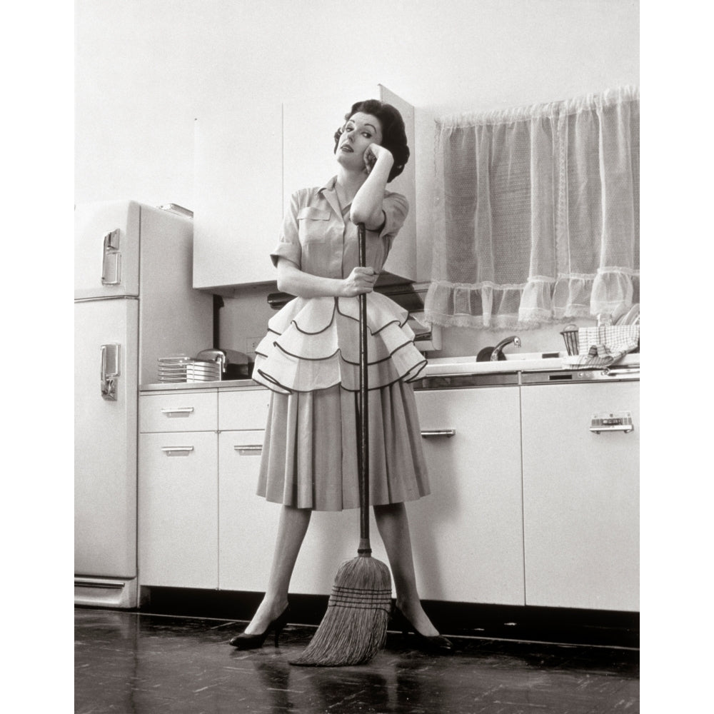 1950s Woman Housewife Standing In Kitchen Leaning On Broom Poster Print By Vintage Collection Image 1