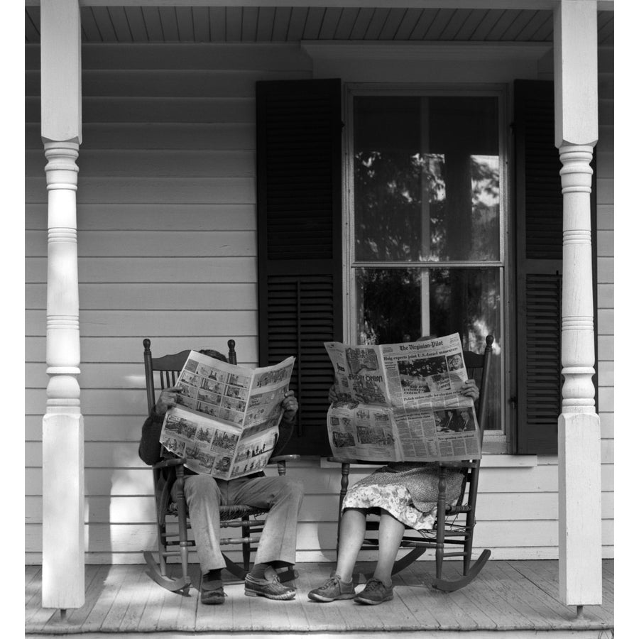 1950s-1960s Couple Man Woman Sitting On Porch In Rocking Chairs Holding Newspapers Up Hiding Their Faces Print By Image 1