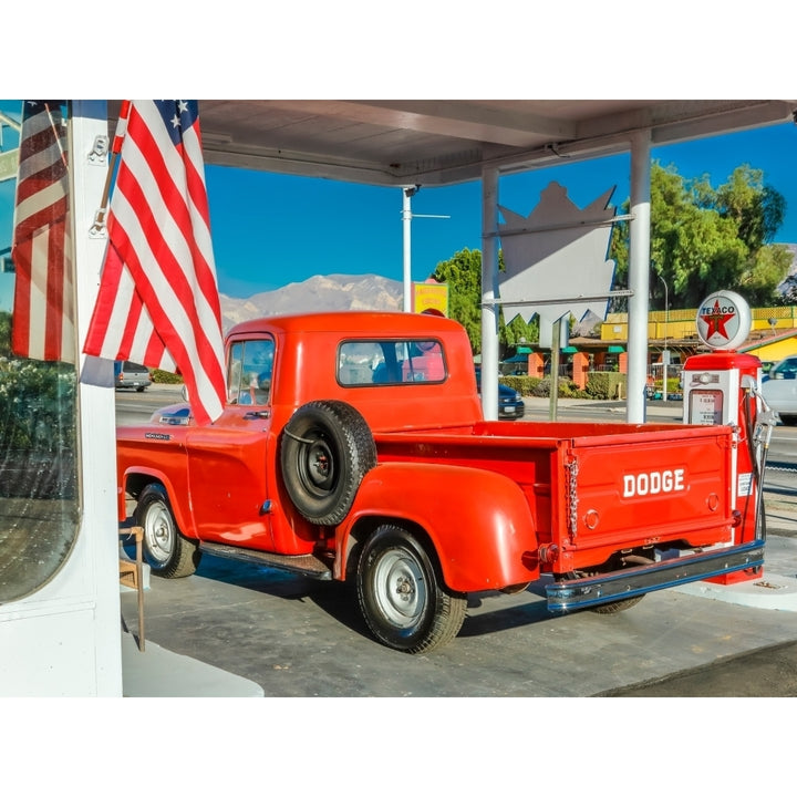 Red Dodge Pickup truck parked in front of vintage gas station in Santa Paula California Print by Panoramic Images Image 1