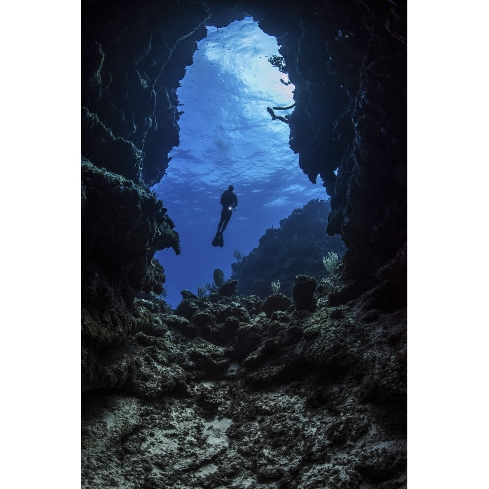 A diver stops at the entrance to an underwater cave in Grand Cayman Cayman Islands Poster Print by Brook Peterson/Stock Image 2