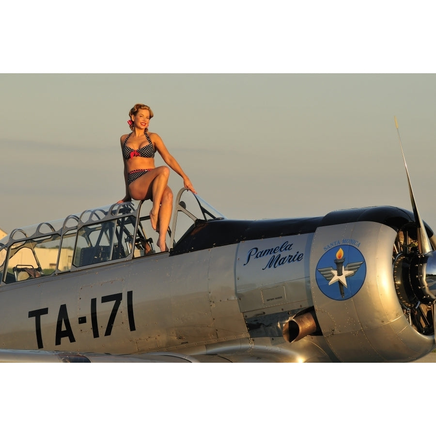 1940s style pin-up girl sitting on the cockpit of a World War II T-6 Texan Poster Print Image 1