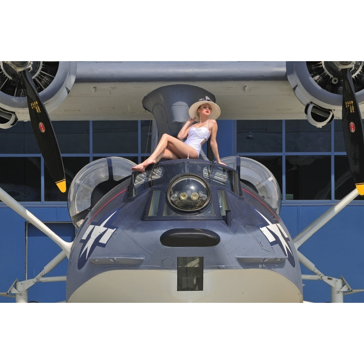 Retro pin-up girl posing with a World War II era PBY Catalina seaplane Poster Print Image 1