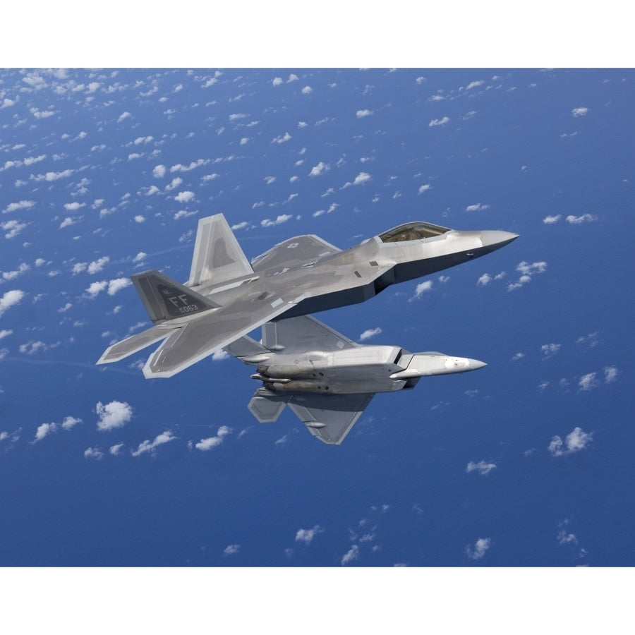 Two F-22 Raptors maneuver while flying a training mission over Japan Poster Print Image 1