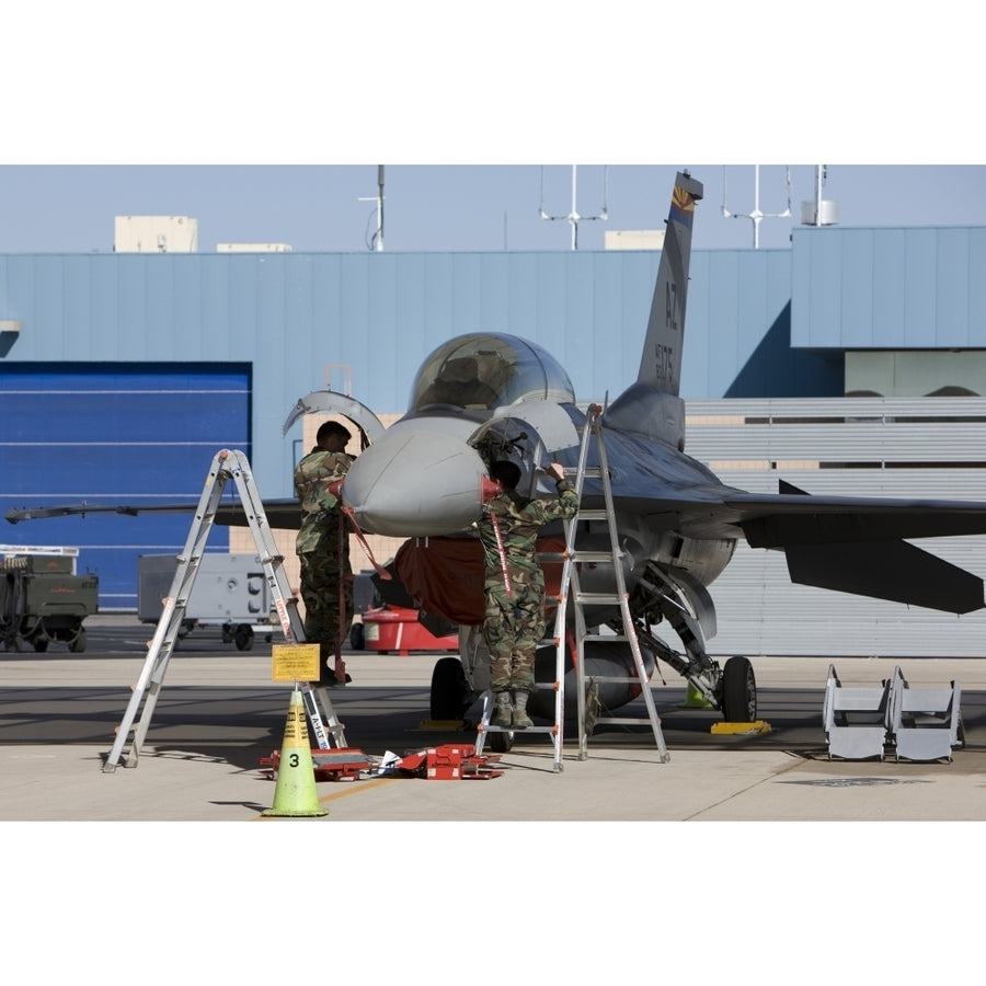 Maintenance personel work on an F-16 Fighting Falcon Poster Print Image 1