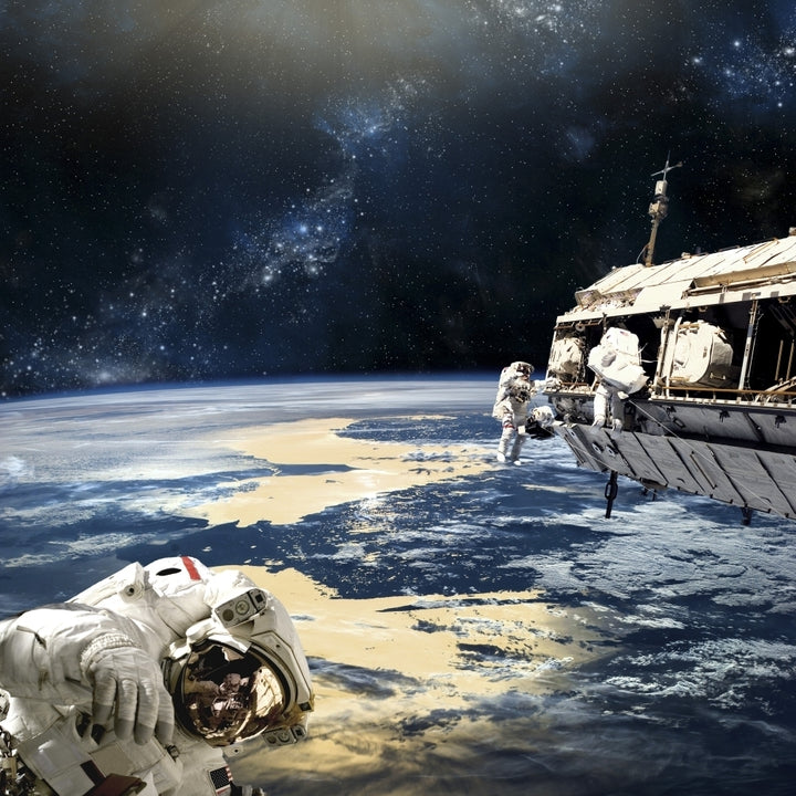 Astronauts working on space station while orbiting an Earth-like planet Poster Print Image 2