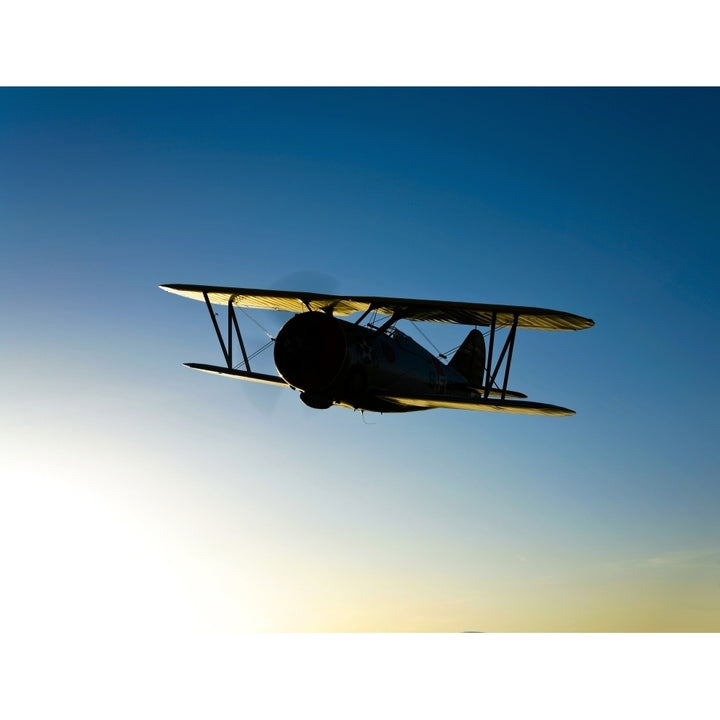 Silhouette of a Grumman F3F biplane in flight Poster Print Image 1