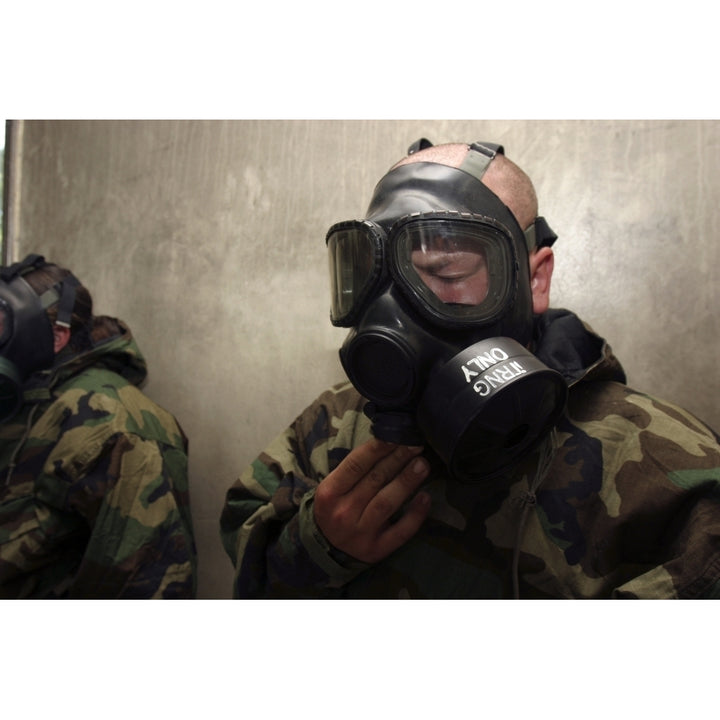 A field radio operator clears CS gas from his gas mask at the gas chamber Poster Print Image 1