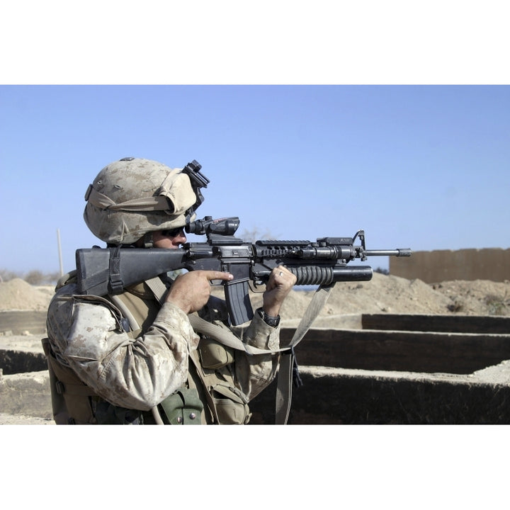 U.S. Marine sites through the scope atop his 5.56mm M16A2 rifle while providing security Poster Print Image 1