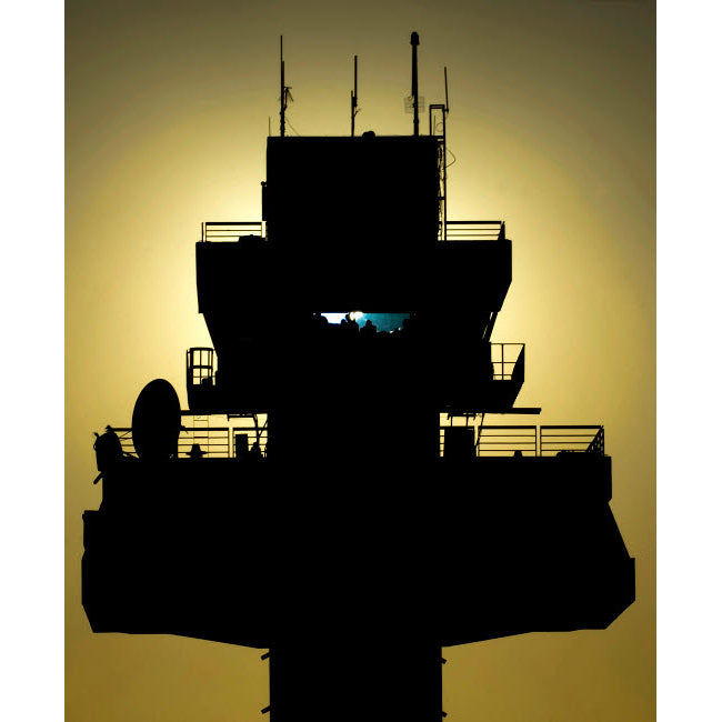 The setting sun silhouettes an air traffic control tower Poster Print by Stocktrek Images Image 1